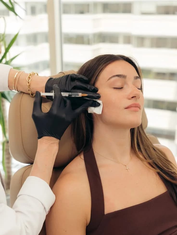 Patiente en fauteuil lors d'une injection du visage